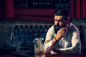 Man with beard holds glass brandy. Bearded guy drink cognac. Man holding a glass of whisky. Sipping whiskey. Portrait of man with thick beard. Macho drinking. Degustation, tasting.