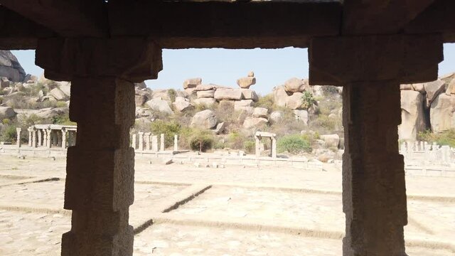 Tracking Shot Past Colonnade Pillar of Ruined Temple at Hampi Archaeological Site, Karnataka, India