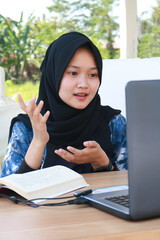 Portrait of a happy woman working on laptop computer