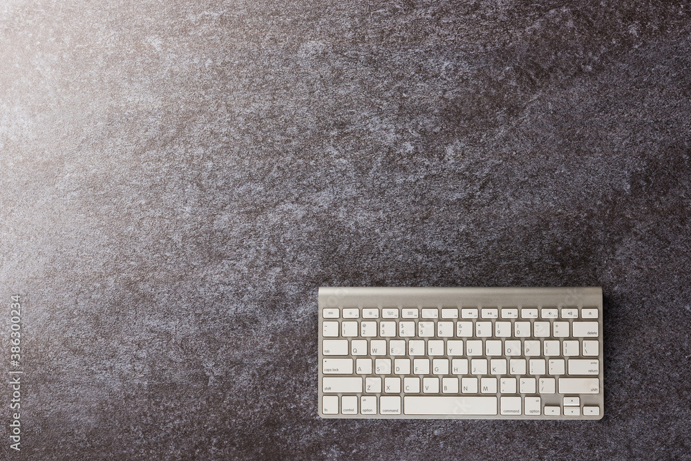 Aufkleber Top view flat lay of a modern white computer keyboard on office desk concrete background with copy space for text