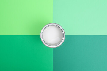 Open paint enamel cans on green palette samples.