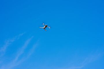 Naklejka na ściany i meble Drone hovering in sky against blue sky