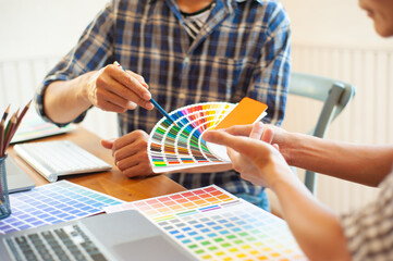 Obraz na płótnie Canvas Two designers discuss the swatch color samples.