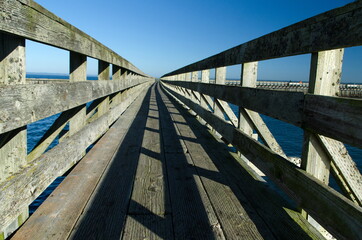 Obraz premium Wooden bridge to wave breaker in Westhaven Cove