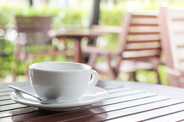  Selective focus of white coffee cup on the table in cafe blurred background  with morning sunlight