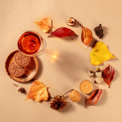 Autumn frame, square banner with dessert wine, biscuits, and autumn leaves, shot from the top with copy space on a brown background