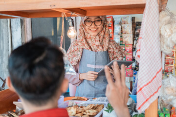 woman seller the cart shop smiles using tablet pc when serving customers at the cart stall