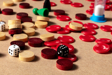 Obraz na płótnie Canvas Board games concept, various pieces and dice, scattered on a table on a brown background