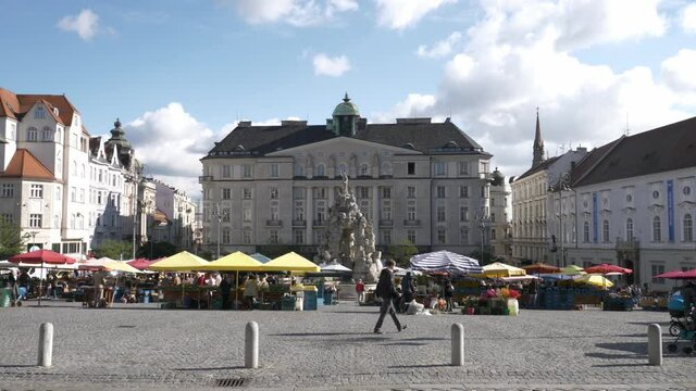 Shoppers amid colorful booths in Zelny Trh Square market , Brno, Czech Republic 