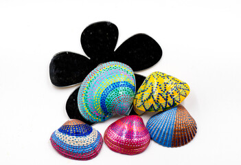 festive and colorful painted shells on a black flower like mirroe