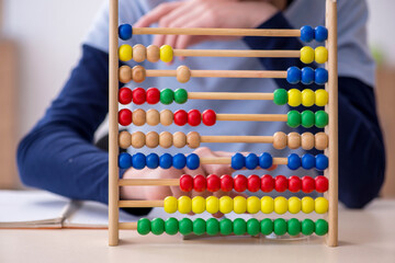 Schoolboy with abacus studying math at home