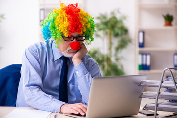 Old businessman clown working in the office