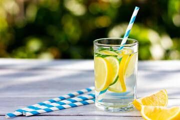 A glass of lemonade with lime and lemon slices. Summer sunny day