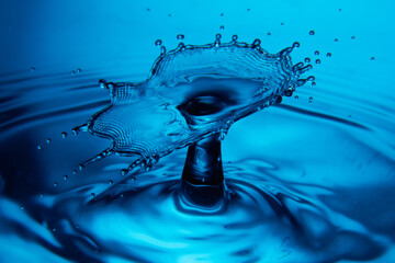 Water drop falling down. Abstract blue background