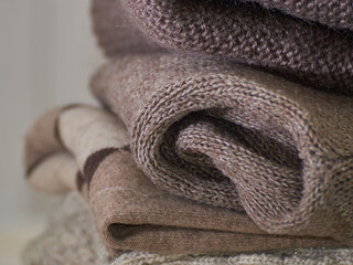Fototapeta na wymiar A stack of cozy knitted woolen clothes. Retro style. Warm comfortable concept. Handwork. Close-up, texture