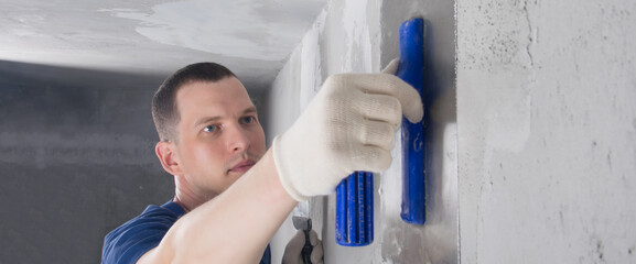 Obraz premium master protective gloves for repair of concrete walls, zashpaklevyvaem the junction of wall ceiling, close-up