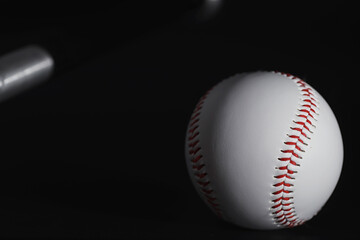 American traditional sports game. Baseball. Concept. Baseball ball and bats on a black table.