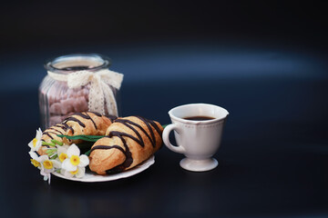 French breakfast on the table. Coffee croissant with chocolate and a decanter with cream. Fresh pastries and decaffeinated coffee.