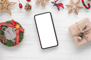 Fototapeta na wymiar Mockup blank white screen smartphone on white desk background for Christmas and New Year, Flat lay top view with copy space for your Merry Christmas and Happy New year artwork.