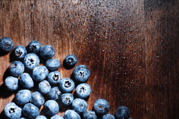 Water drops on ripe sweet blueberry. Fresh blueberries background with copy space for your text. Vegan and vegetarian concept. Macro texture of blueberry berries.