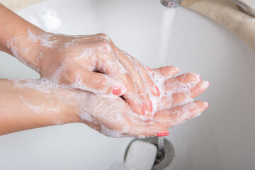 Fototapeta premium Woman use soap and washing hands under the water tap. Hygiene concept hand detail