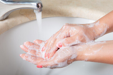 Coronavirus pandemic prevention wash hands with soap warm water and , rubbing nails and fingers...