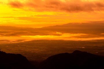 Beautiful landscape at sunset sky with clouds on peak of mountains.