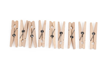 Row of wooden clothespins on a white background, top view
