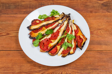 Baked eggplant stuffed with tomatoes and cheese on white dish