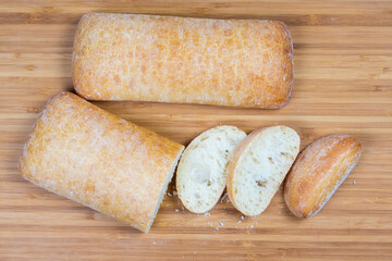 Top view partly cut and whole ciabatta on cutting board