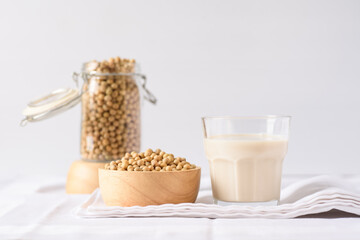 Soy milk in glass and soy bean on white background
