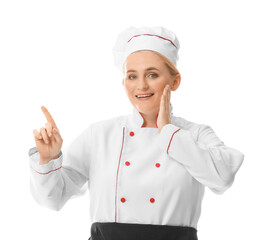 Mature female chef pointing at something on white background