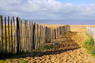 Fototapeta na wymiar pedestrian path for access to the sand of the beach protected by wooden barriers