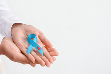 Woman with awareness ribbon on white background, closeup. Diabetes concept