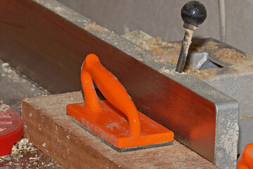 The pusher rests against a wooden billet for safe operation on the jointer