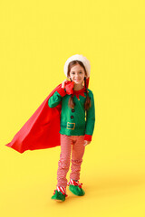 Cute little girl dressed as elf and with Santa Claus bag on color background