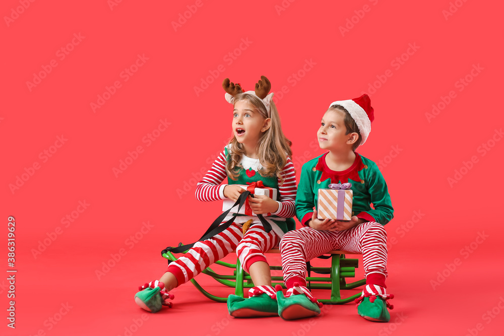 Sticker cute little elves with christmas gifts and sledge on color background