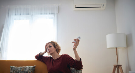 Woman using aircondition unit at home.