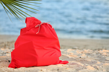 Santa Claus bag with gifts on beach