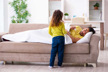 Fototapeta premium Small girl looking after her sick father