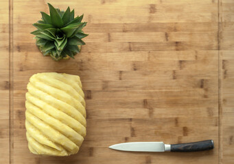 Ripe perfectly peeled pineapple, on a wooden background.