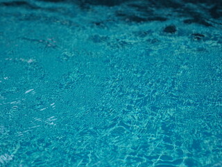 blue water in pool background ripples on the surface texture, glittering bokeh abstract