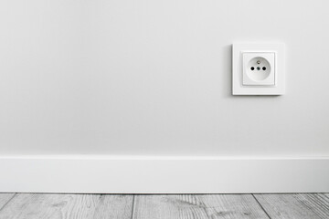 Electrical socket isolated on gray wall. Renovated studio apartment power supply background. Empty...