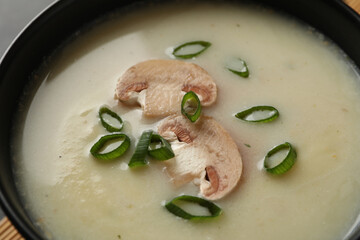 Bowl of tasty mushroom soup with champignons, close up