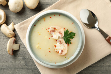 Concept of tasty lunch with bowl of mushroom soup on gray background