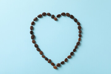 Heart made of coffee beans on blue background