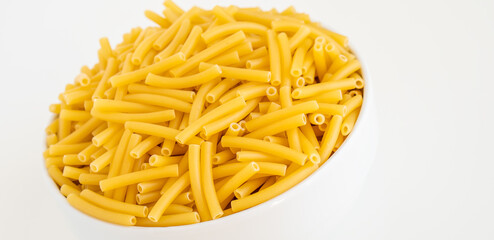 Raw dry uncooked Macaroni pasta spaghetti noodle on white bowl wooden background for basil tomato pesto sauce Homemade Italian food organic whole wheat vegan spaghetti for a healthy meal
