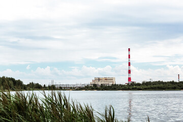 Fototapeta na wymiar Combined heat and power plant and a lake with cooling fountains. CHP for the production and supply of the city's population with electricity and hot central water supply. Technology and nature