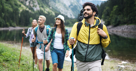 Group of fit healthy friends trekking in the mountains - obrazy, fototapety, plakaty