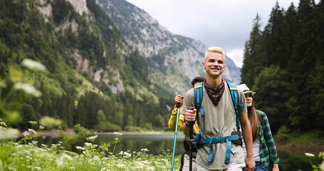 Group of happy friends with backpacks hiking together